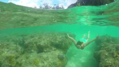 yavaş hareket: genç kız inanılmaz mercan resifleri üzerinde sığ sularda yüzme