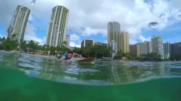 Счастливый молодой серфер греблей на пляже Вайкики, Гавайи — стоковое видео