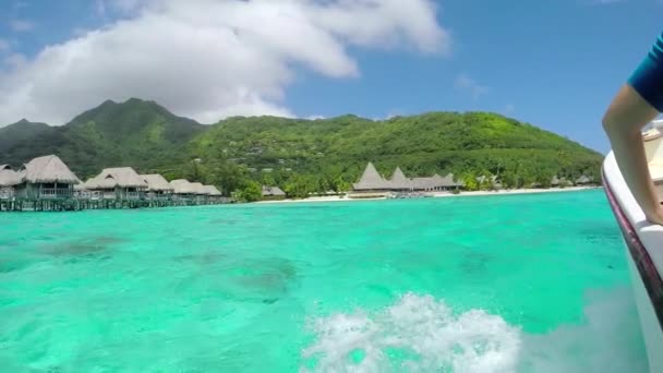 Zeitlupe: Bootsfahrt vorbei an luxuriösen Überwasser-Villen auf sonniger exotischer Insel — Stockvideo