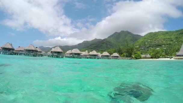 Slow Motion: boottocht langs luxe boven het watervilla's in strand exotische eiland — Stockvideo