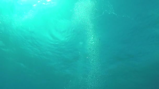 UNDERWATER: Manny big air bubbles rising up to the rippling ocean surface — Stock Video