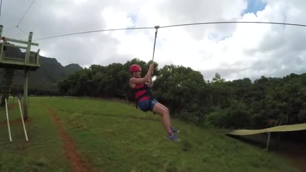 Ung lycklig flicka glider på kabel högt över frodig djungel regnskog trädkronorna — Stockvideo