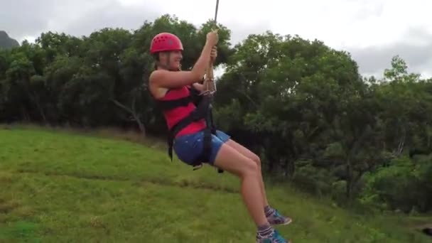 Ung flicka ler, skriker och har kul medan zipling ovanför frodig regnskog — Stockvideo