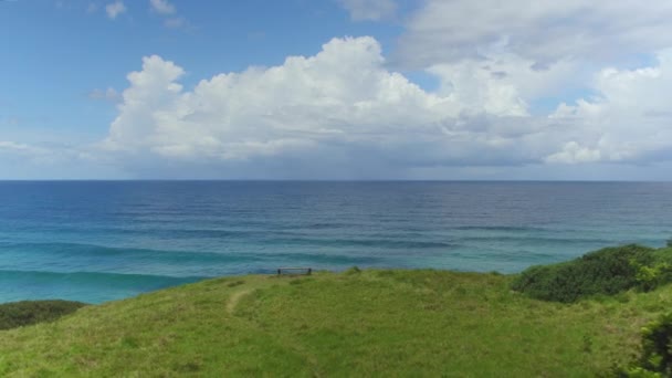 AERIAL: Banco solitário com vista deslumbrante do oceano azul-turquesa sem fim no verão — Vídeo de Stock