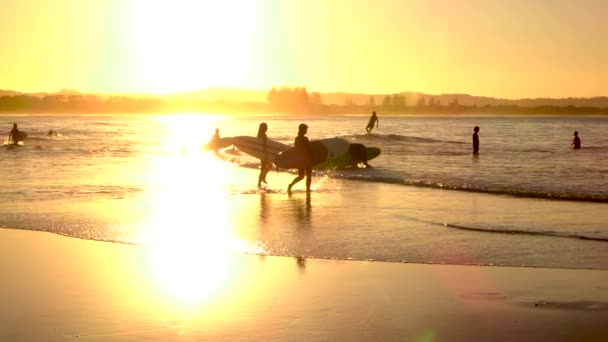 SLOW MOTION: Happy surf people enjoying surfing in ocean at golden sunset — Stock Video