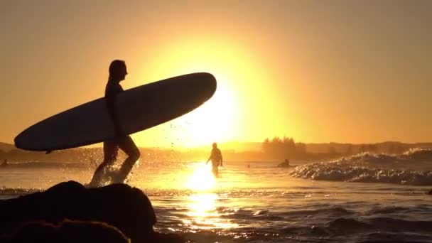 MOCIÓN LENTA: Joven surfista aventurera corriendo en el océano con tabla de surf — Vídeos de Stock