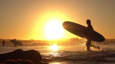 Ağır çekim: okyanusa surfboard ile çalışan heyecanlı genç sörfçü kız