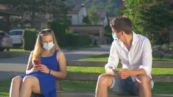 CLOSE UP: Man scoots away from woman while sitting on a public bench. — Stock Video