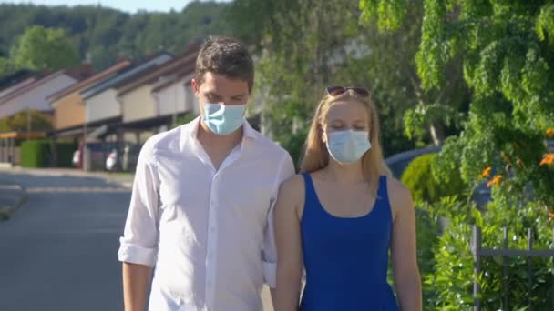 AFSLUITEN: jong stel zoenen door hun maskers tijdens een romantische wandeling. — Stockvideo