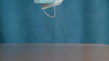 Coronavirus koruyucu yüz maskeleri parlak ahşap masanın üzerine düşer..