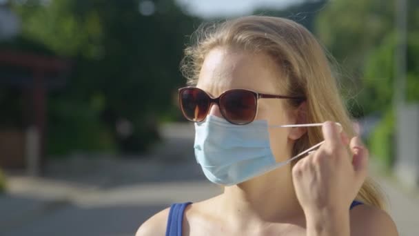 FERMER : Une jeune femme respire profondément après avoir enlevé son masque chirurgical — Video