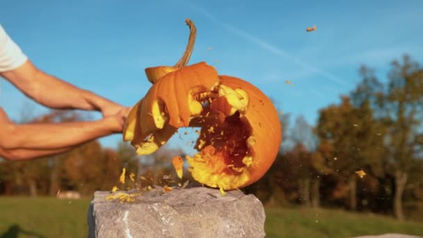Movimiento lento: Calabaza de Halloween con la cara conmocionada se rompe con el bate de béisbol — Vídeos de Stock