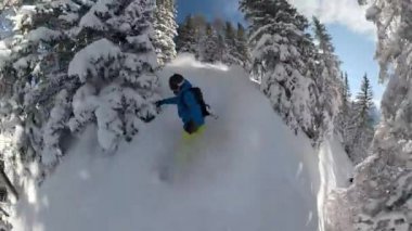 Güneşli bir günde, kış tatilinde snowboard yaparken çekilmiş havalı bir fotoğraf..