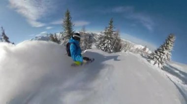 Snowboardcu ormanda at sürerken taze toz kar oyuyor.