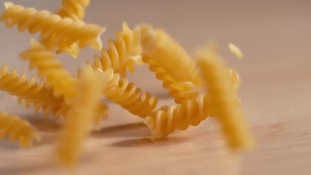 MACRO, DOF: Colpo cinematografico di pasta secca che rimbalza attorno al tavolo della sala da pranzo. — Video Stock