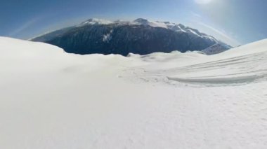 Güneşli bir kış gününde Kanada 'nın el değmemiş kırsalında snowboard yapmak.