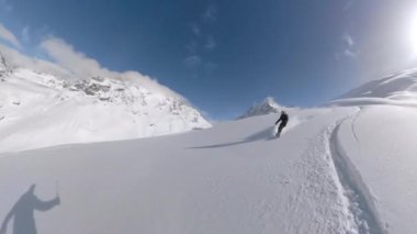 Rocky Dağları 'nın kırsalında sporcular snowboard yapıyor..