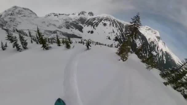POV Két snowboardos friss havat aprít, miközben a Sziklás-hegységben deszkáznak. — Stock videók