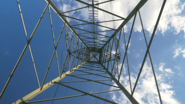 BOTTOM UP: Nubes flotan sobre una torre que proporciona electricidad a los alrededores. — Vídeo de stock