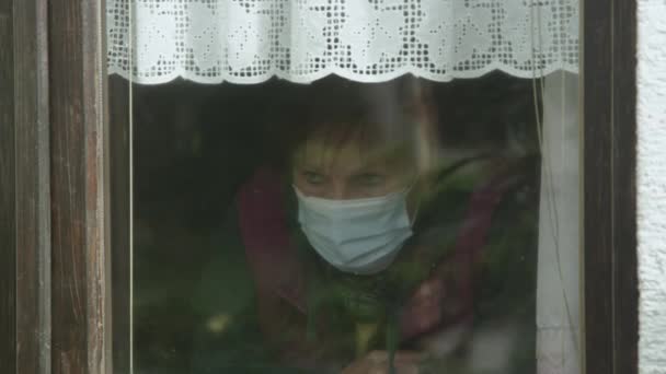 CLOSE UP: Самотня леді з тривогою спостерігає за околицями в розпал пандемії . — стокове відео