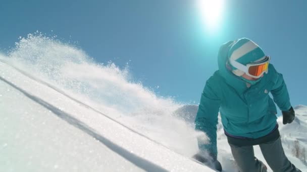 CLOSE UP: Snowboarder drags her hand along powder snow while riding off trail. — Stock Video