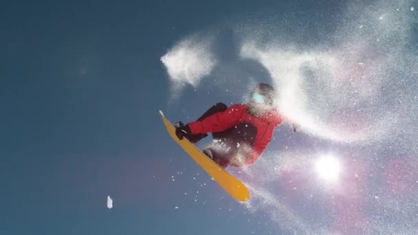 BOTTOM UP:キーカーをオフに乗っている間に恐れのない男性スノーボーダーはスピントリックを行います — ストック動画