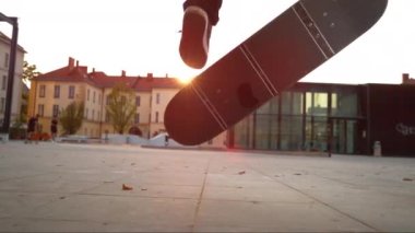Gün batımında nollie kickflip yapan bir kaykaycının sinematik çekimi..