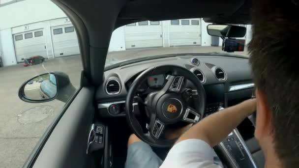 Felismerhetetlen férfi felvesz egy fekete sisakot, és beszáll egy Porsche-ba.. — Stock videók