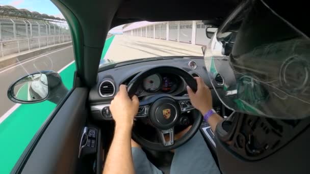 CLOSE UP: Man cruises langs de pitlane van een racebaan open voor benzinekoppen. — Stockvideo