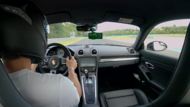 CERRAR: Hombre con casco de carreras contra otros pilotos y tiempo en un Porsche — Vídeos de Stock