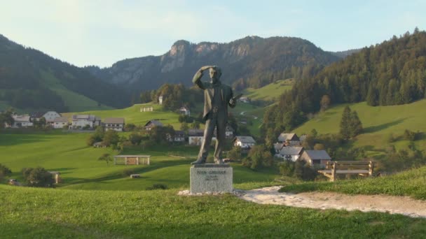 Statua słynnego słoweńskiego malarza otoczona jest złotym światłem krajobrazu. — Wideo stockowe