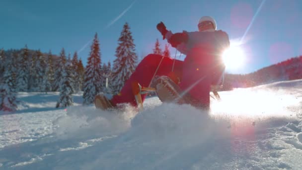 LENS FLARE: Glada kvinna pulka ner snöig kulle i soliga slovenska bergen. — Stockvideo