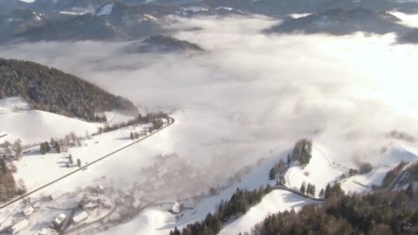 AERIAL: repül felett idilli havas vidék Bohinj csomagolva köd. — Stock videók
