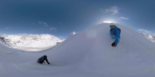 Vrouw spuit vriendje met vers poeder tijdens het snowboarden in Rockies. — Stockvideo