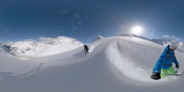 Spektakularne góry otaczają kilka snowboardów z trasy zjazdowej. — Wideo stockowe