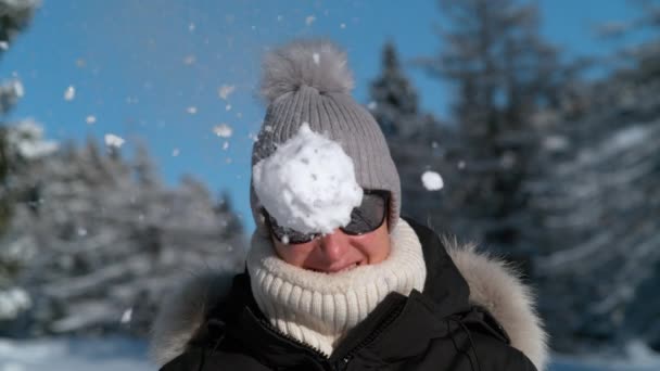 Ritratto: Una turista sorridente viene colpita in faccia da una soffice palla di neve. — Video Stock