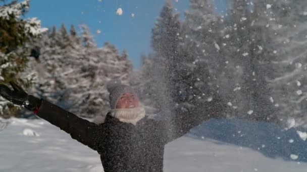 FERMETURE : Une touriste joyeuse jette une poignée de neige fraîche dans l'air. — Video