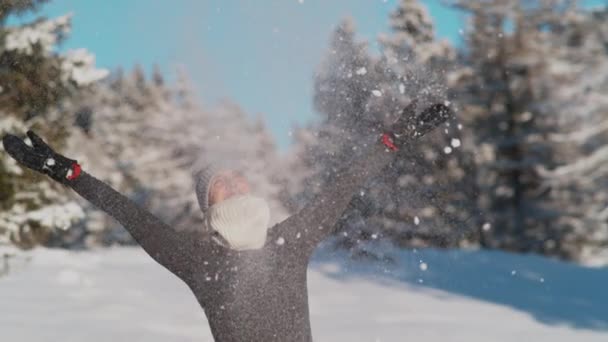 CERRAR: Mujer joven se divierte en el campo nevado jugando con la nieve. — Vídeos de Stock