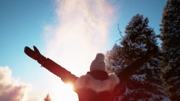 Κοντινό πλάνο: αγνώριστη γυναίκα ρίχνει φρέσκο χιόνι σε σκόνη στον αέρα κατά το ηλιοβασίλεμα. — Αρχείο Βίντεο