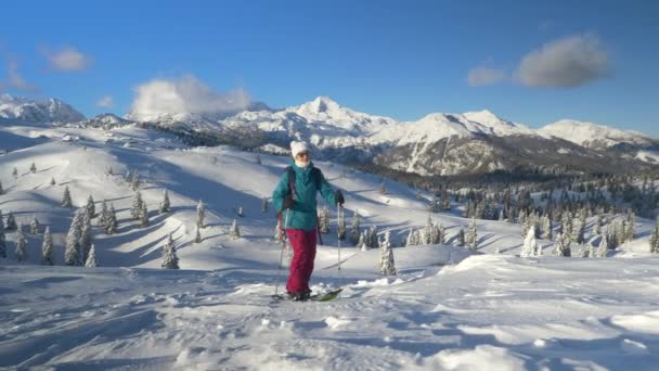 COPY SPACE: Una donna in gita sciistica in Slovenia cammina su una collina innevata. — Video Stock