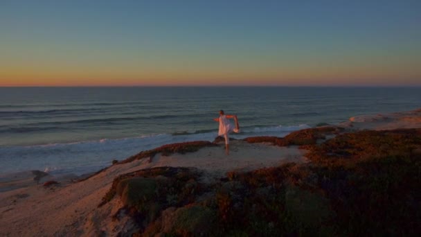 DRONE: Jovem ativa em férias de verão faz ioga em uma noite ensolarada. — Vídeo de Stock