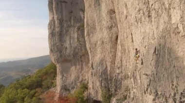 Slovenya 'da bir uçuruma tırmanan korkusuz bir kaya tırmanıcısının yanından uçuyor..
