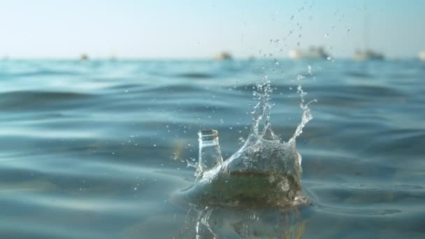 FECHAR UP: Garrafa de cerveja Corona vazia é despejada no mar perto de barcos ancorados. — Vídeo de Stock