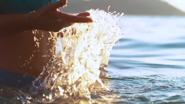 CERRAR: Mujer irreconocible en bikini azul salpica agua de mar con las manos. — Vídeo de stock