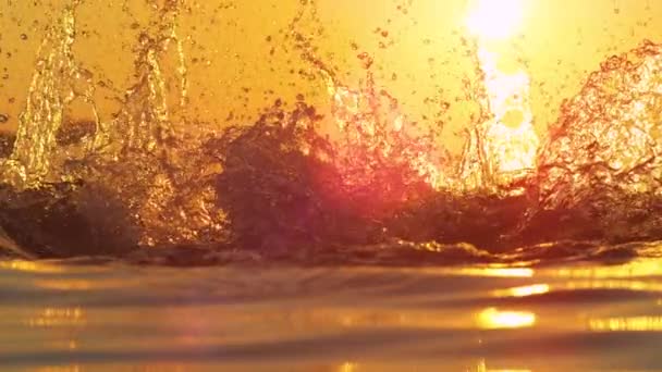 CLOSE UP: Detailed shot of crystal clear ocean water splashing into evening sky. — Stock Video