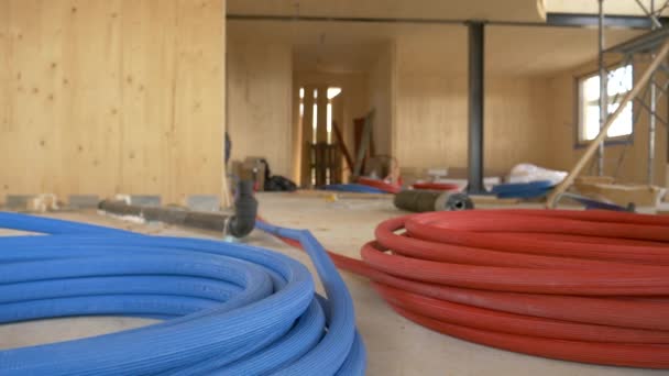LOW ANGLE: spolar av färgglada gummislangar ligger på marken på en byggarbetsplats. — Stockvideo