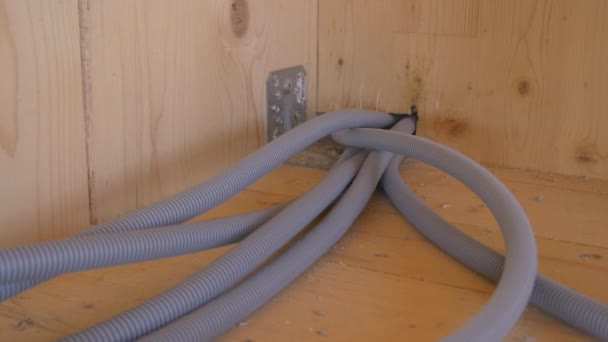 CLOSE UP: Internetleitungen kommen aus einem Loch in der Holzwand und durchqueren einen Raum. — Stockvideo