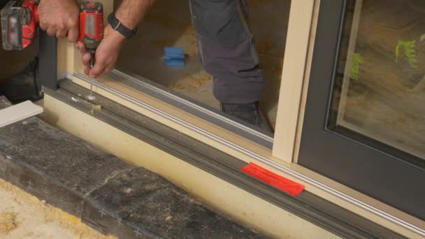 CLOSE UP: Unrecognizable contractor drills a hole while mounting a window. — Stock Video