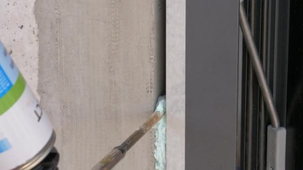 CLOSE UP: Spraypistol fyller upp ett mellanrum mellan en vägg och fönster med tätningsmedel. — Stockvideo