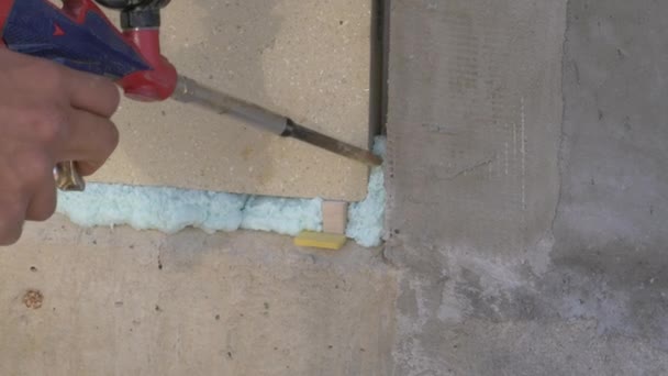 CLOSE UP: Monteringsfönster sprutar polyuretanskum i ett litet mellanrum. — Stockvideo